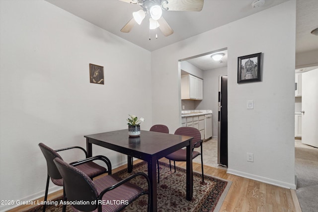 dining area with ceiling fan and light hardwood / wood-style flooring