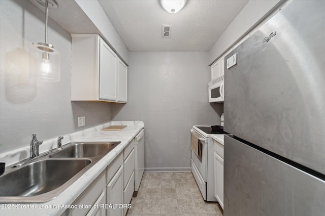 kitchen featuring sink, white cabinets, hanging light fixtures, white appliances, and a textured ceiling