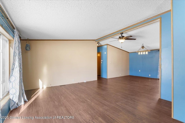 spare room with ornamental molding, dark wood-type flooring, and a textured ceiling