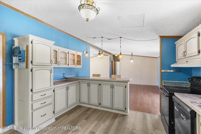 kitchen with decorative light fixtures, black appliances, kitchen peninsula, and light wood-type flooring