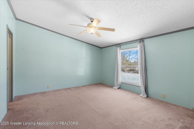 carpeted spare room with crown molding, ceiling fan, and a textured ceiling