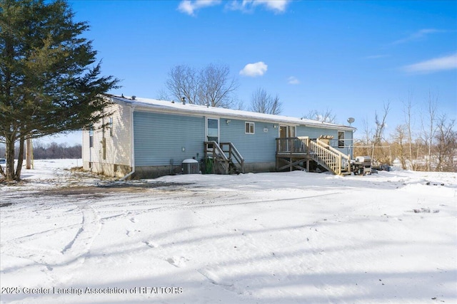 snow covered property with central AC