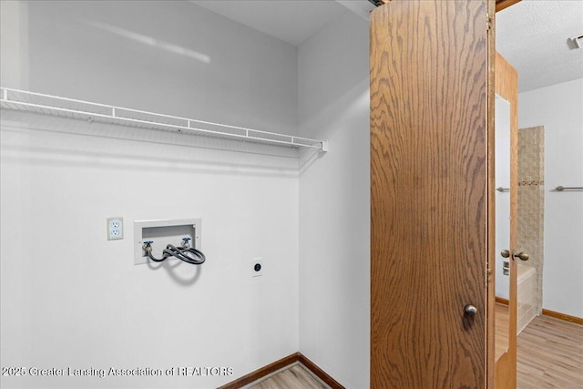 clothes washing area with washer hookup, hardwood / wood-style flooring, and hookup for an electric dryer