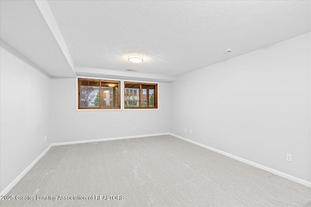 unfurnished room featuring a textured ceiling and carpet