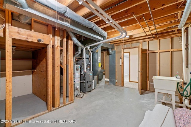 basement featuring heating unit and sink