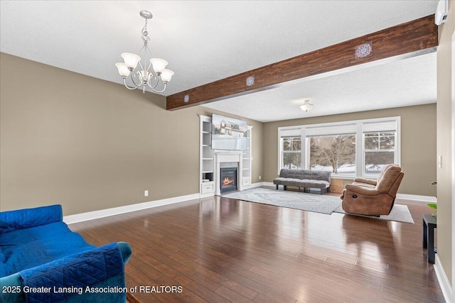 living room with a textured ceiling, a chandelier, dark hardwood / wood-style floors, and beamed ceiling