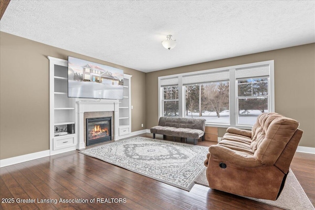 living room featuring dark wood-type flooring and a textured ceiling