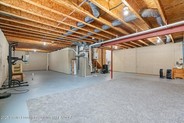 basement featuring electric panel and water heater