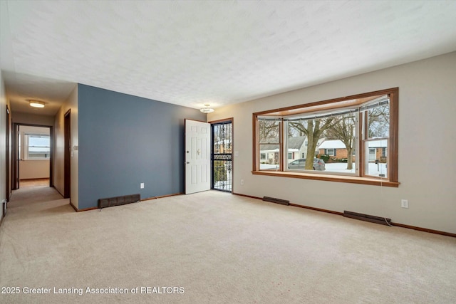 carpeted spare room with a textured ceiling