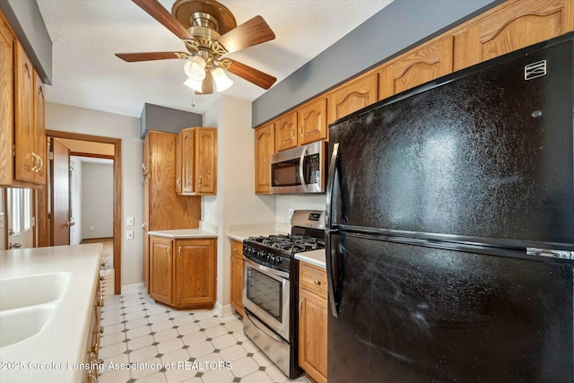 kitchen with appliances with stainless steel finishes, sink, a textured ceiling, and ceiling fan