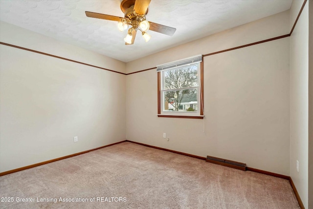 spare room with ceiling fan and carpet