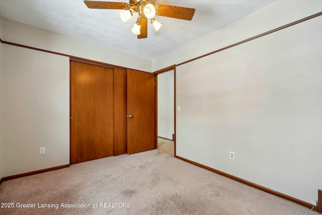 unfurnished bedroom featuring ceiling fan, a closet, and light carpet