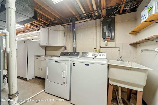 clothes washing area featuring sink, washing machine and dryer, cabinets, and electric panel