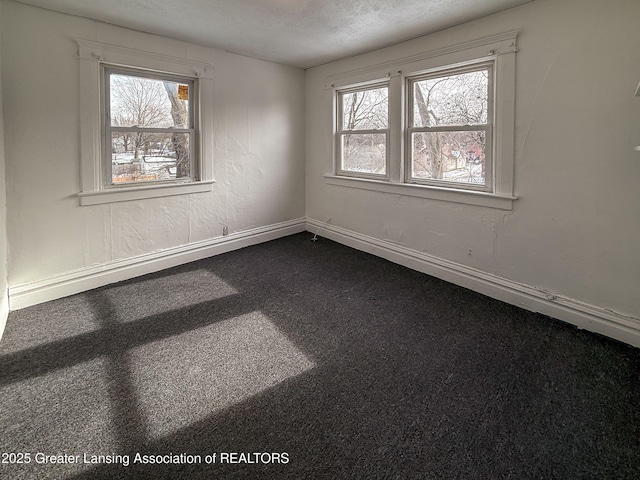 carpeted spare room with a textured ceiling