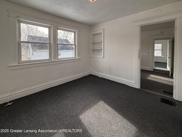 carpeted spare room featuring a textured ceiling