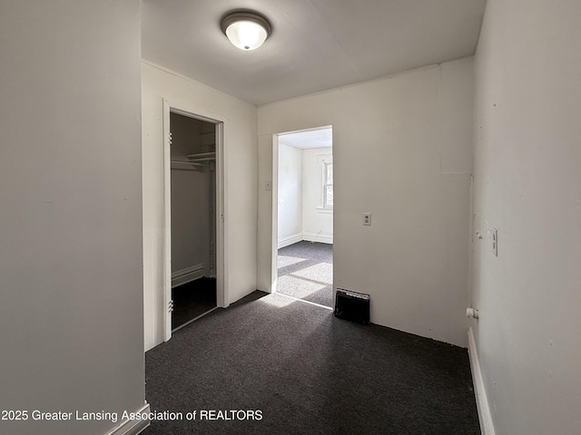 unfurnished bedroom with a closet and dark colored carpet