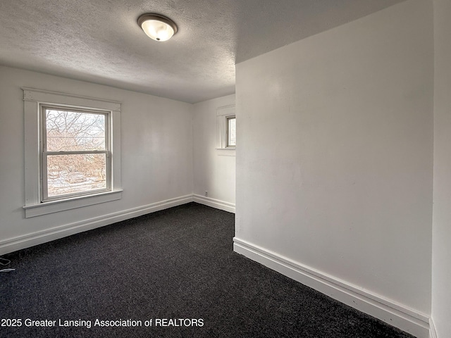 carpeted spare room with a textured ceiling