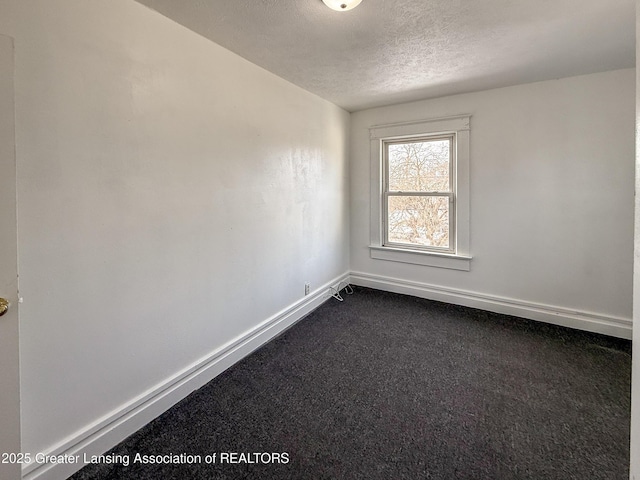 carpeted empty room featuring a textured ceiling