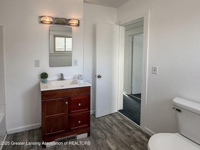 bathroom featuring vanity, hardwood / wood-style floors, and toilet