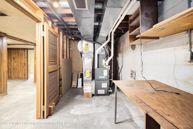 basement with heating unit and wooden walls