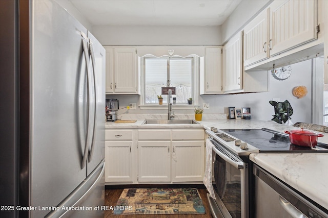 kitchen featuring white cabinetry, appliances with stainless steel finishes, sink, and dark wood-type flooring