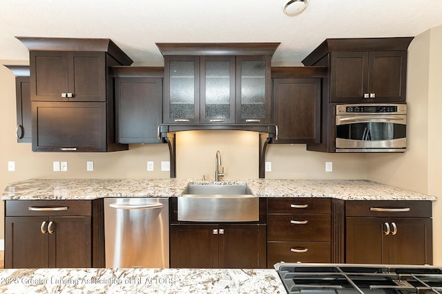 kitchen featuring appliances with stainless steel finishes, sink, and dark brown cabinets