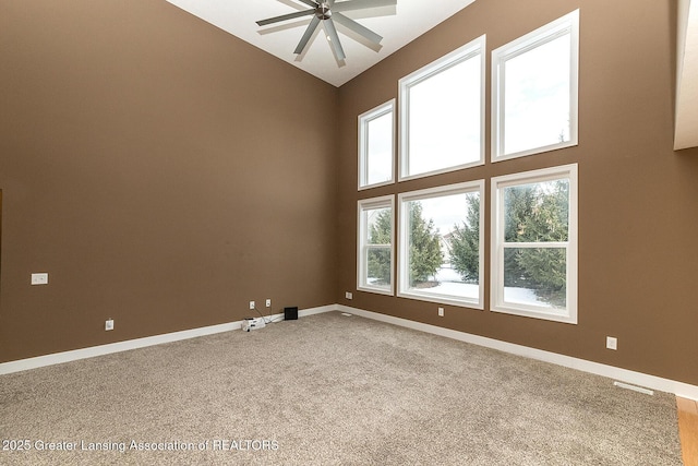 spare room featuring high vaulted ceiling, ceiling fan, and carpet flooring