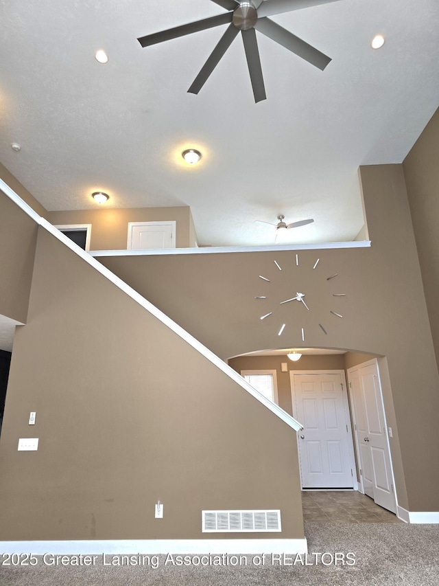 stairway featuring visible vents, ceiling fan, carpet flooring, high vaulted ceiling, and recessed lighting