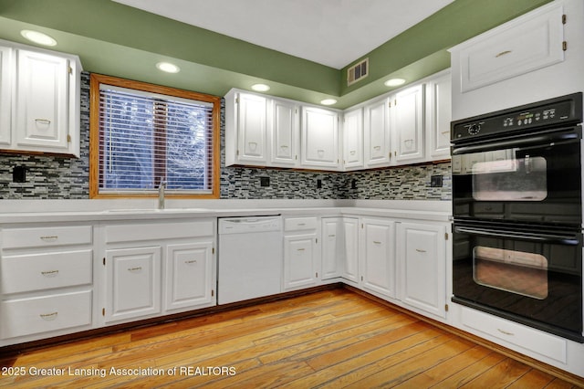 kitchen with sink, white cabinetry, tasteful backsplash, dishwasher, and double oven