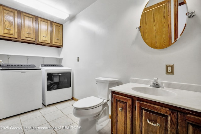 bathroom with tile patterned flooring, washing machine and dryer, vanity, and toilet