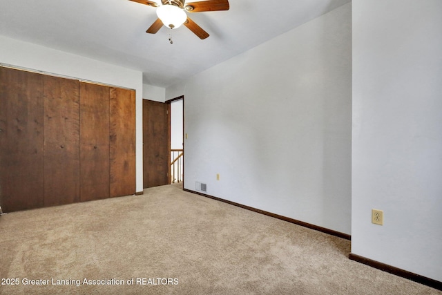 unfurnished bedroom with light colored carpet, ceiling fan, and a closet