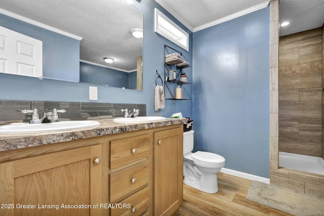 bathroom featuring hardwood / wood-style floors, crown molding, toilet, and a textured ceiling