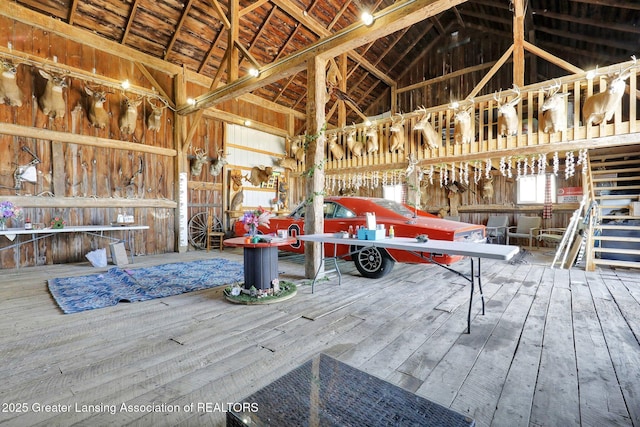 miscellaneous room with hardwood / wood-style flooring, high vaulted ceiling, and a workshop area