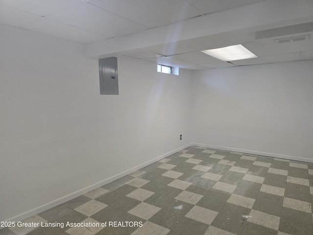 basement with a drop ceiling and electric panel