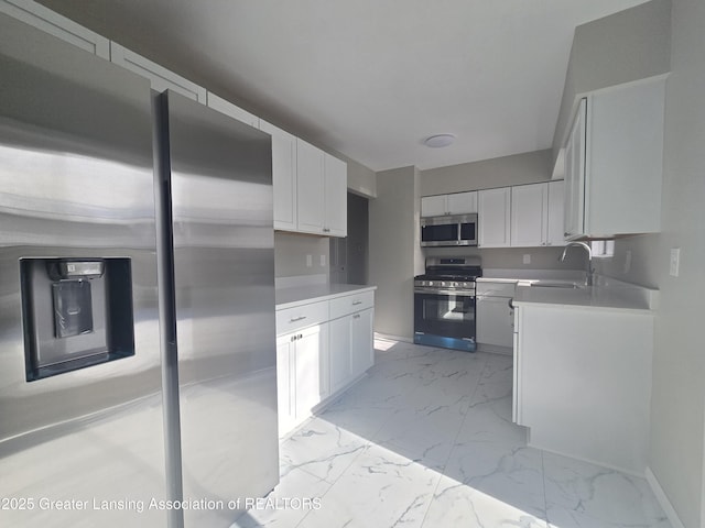 kitchen featuring white cabinetry, stainless steel appliances, and sink