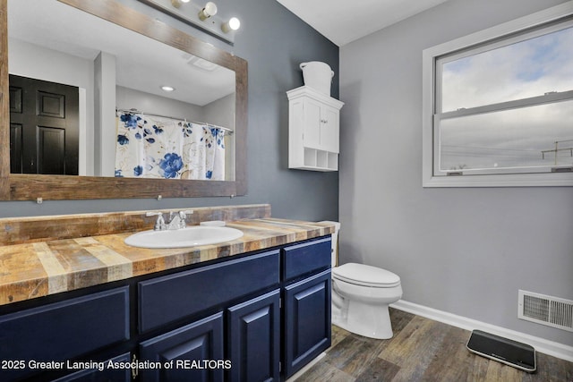 bathroom with a shower with curtain, vanity, toilet, and wood-type flooring