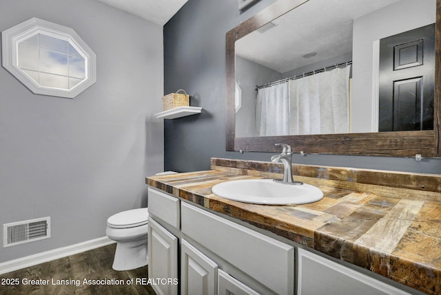 bathroom featuring vanity, toilet, and wood-type flooring