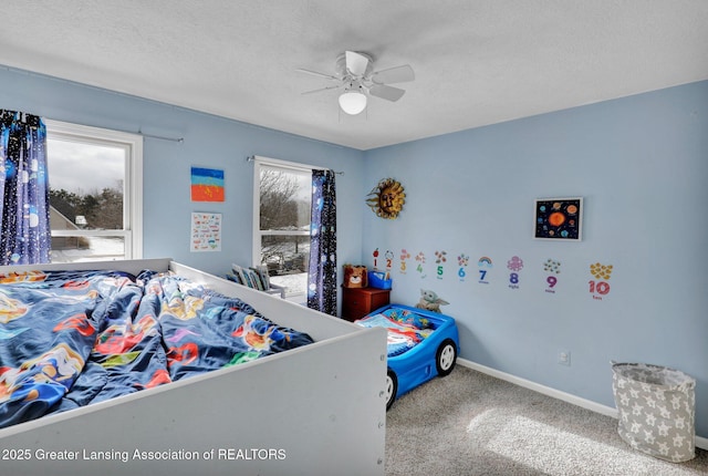 bedroom with ceiling fan, carpet floors, and a textured ceiling