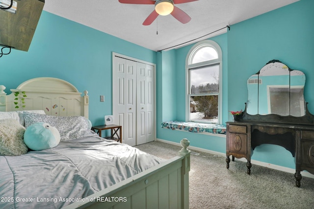 carpeted bedroom with ceiling fan, a closet, and a textured ceiling