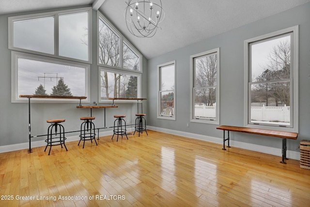 interior space featuring a wealth of natural light, hardwood / wood-style floors, and a notable chandelier