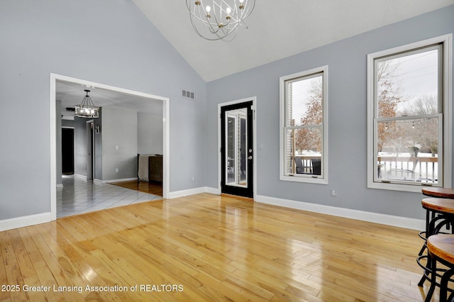 interior space featuring a notable chandelier, hardwood / wood-style flooring, and high vaulted ceiling