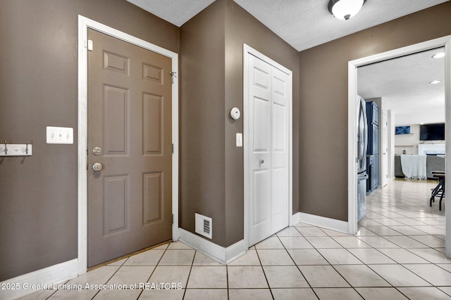 tiled entrance foyer featuring a textured ceiling