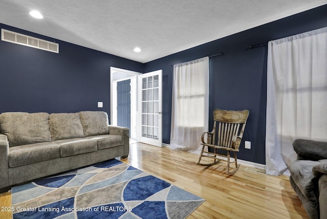 living room featuring hardwood / wood-style flooring and a textured ceiling