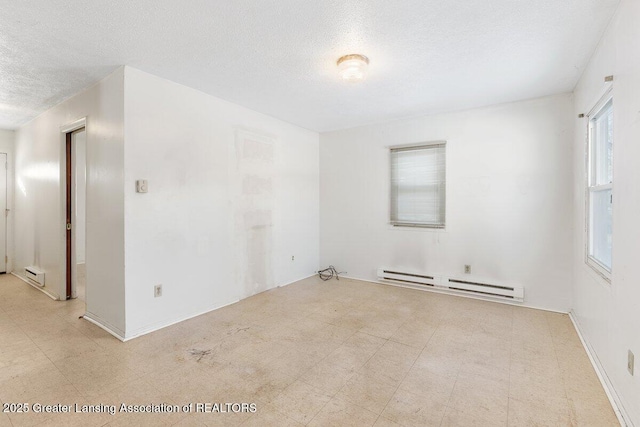 empty room with a textured ceiling and baseboard heating