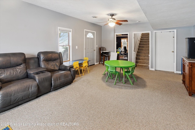 carpeted living room with ceiling fan