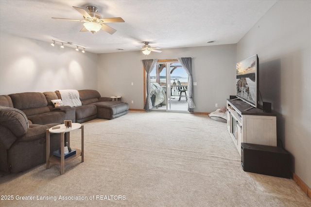 living room featuring ceiling fan, light carpet, and a textured ceiling