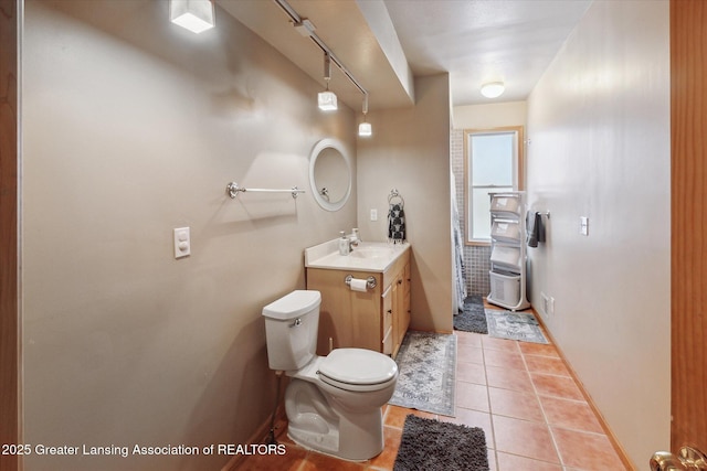 bathroom with vanity, track lighting, tile patterned floors, and toilet