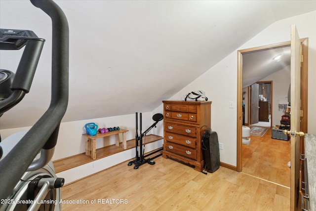 exercise area featuring vaulted ceiling and light wood-type flooring