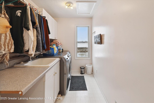 clothes washing area featuring cabinets, sink, and washing machine and clothes dryer