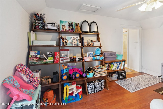 interior space with ceiling fan, lofted ceiling, and wood-type flooring